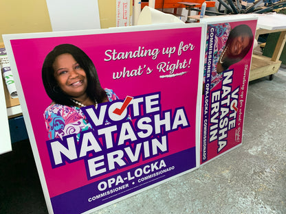 Political campaign signs for Natasha Ervin with a pink and purple color scheme.