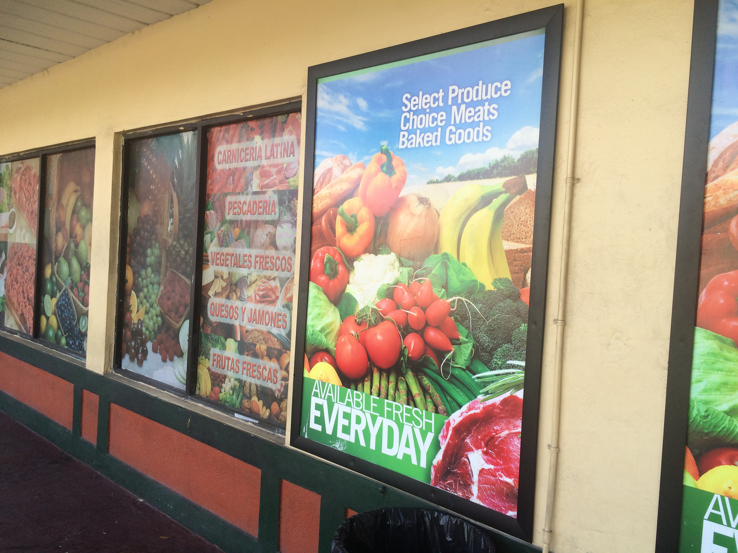 Grocery store display with various product categories on posters.