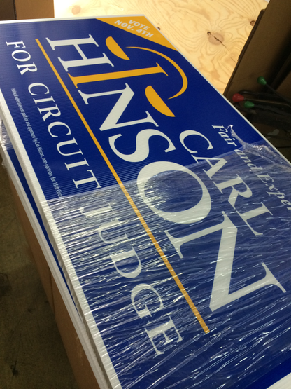 Political campaign sign for Carl Hinson with text 'For Circuit Judge' on a blue background.