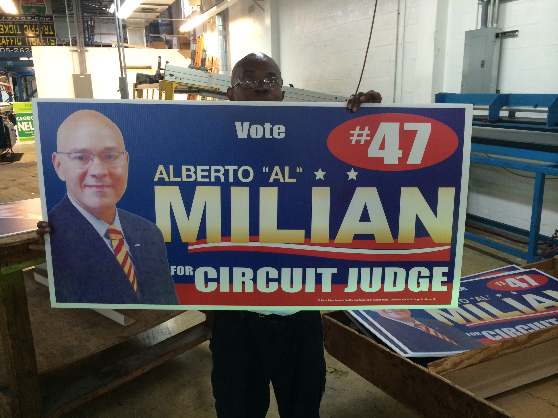Person holding a political campaign sign for Alberto 'Al' Milian for Circuit Judge.