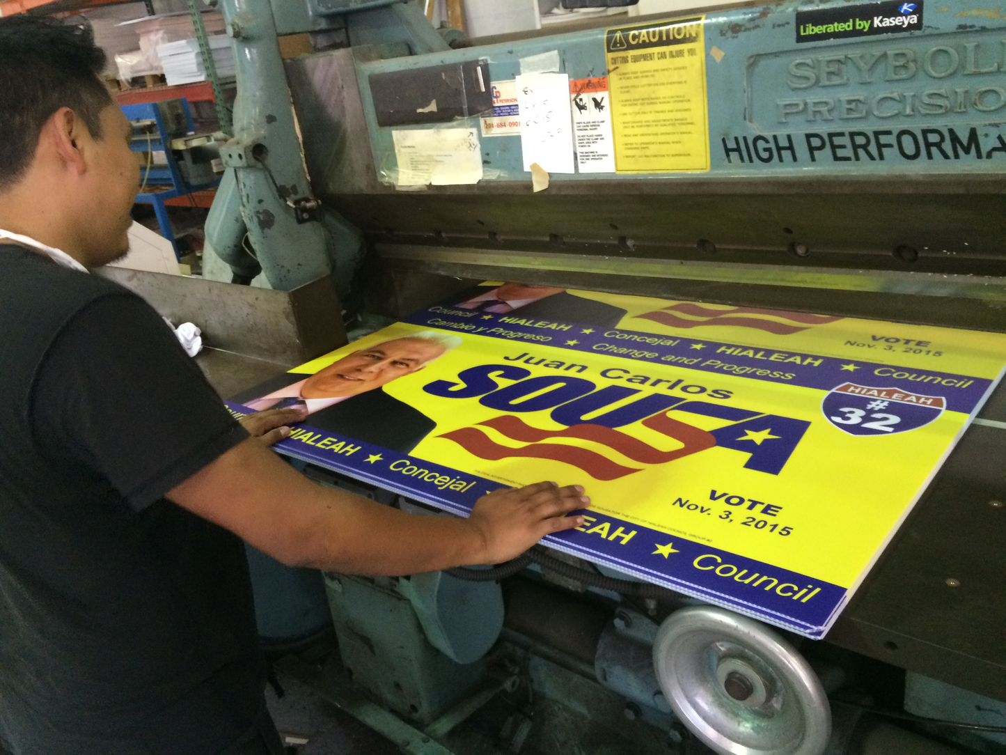 Person working with a political campaign sign on a printing machine.