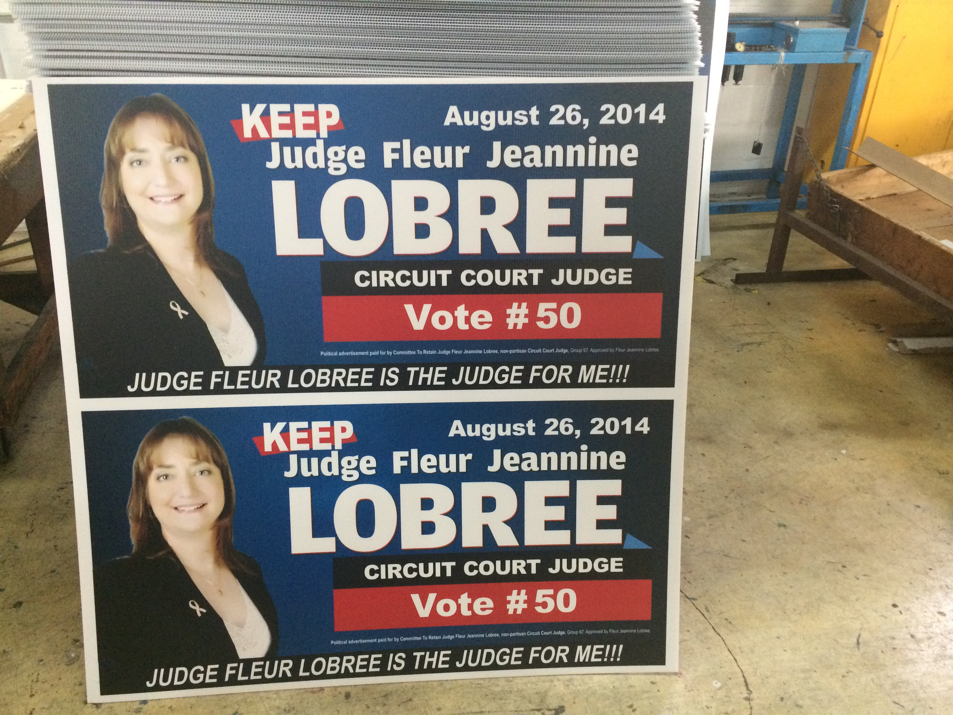 Two political campaign signs for Judge Fleur Jeannine Lobree on a stand.